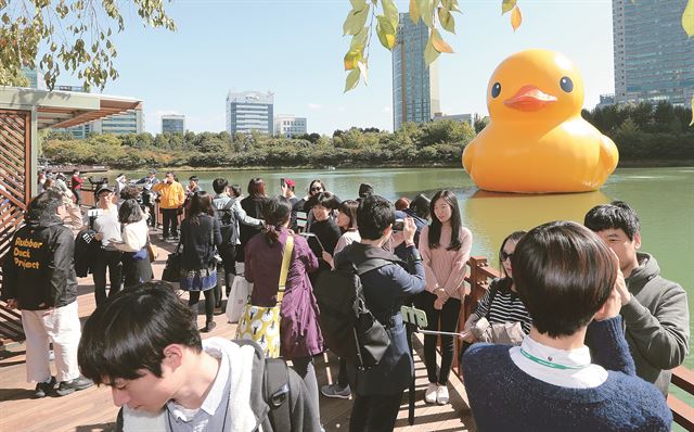 14일 서울 송파구 석촌호수를 찾은 시민들이 대형 고무 오리 '러버덕(Rubber Duck)'을 관람하고 있다. 연합뉴스