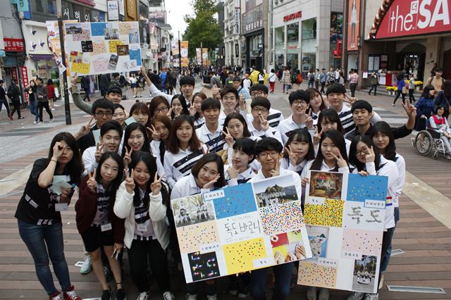 독도 바르게 알기 운동 대학생 서포터즈인 ‘독도 바로니’들이 지난 12일 대구 중구 동성로 대구백화점 앞 광장에서 일반 시민들을 대상으로 독도를 가장 잘 보여주는 사진에 스티커를 붙이도록 하는 ‘독도 나타내는 사진 콘테스트’를 한 뒤 패널을 들어 보이고 있다.