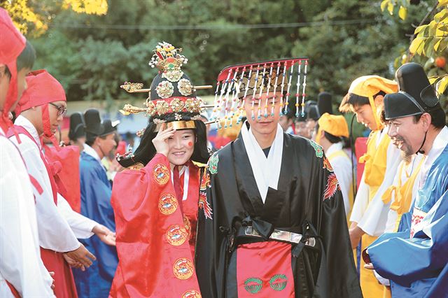 11일 서울 성북구 장위동 부마가옥에서 진행된 궁중혼례식에서 공주와 부마로 각각 분한 석혜진(왼쪽), 이정희씨 부부가 주민들의 축하를 받으며 행진하고 있다. 성북구청 제공.