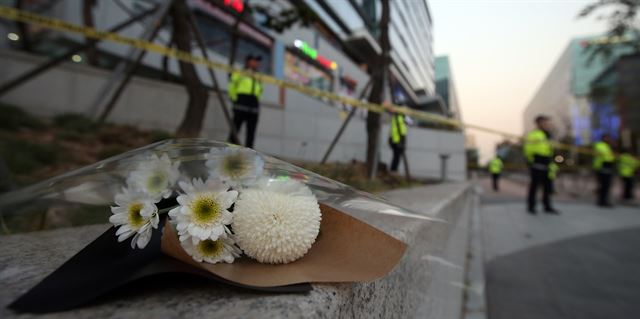 18일 오후 환풍구 덮개 붕괴 사고로 16명이 숨진 경기도 성남시 분당구 판교테크노밸리 야외광장의 환풍구 주변에 국화 꽃다발이 놓여 있다. 연합뉴스