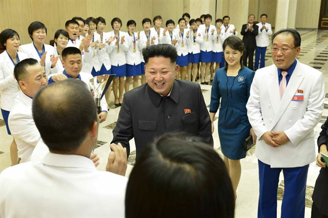 북한 노동당 기관지 노동신문은 김정은 국방위원회 제1위원장(사진 가운데)이 부인 리설주(김정은 오른쪽)와 함께 최근 열린 인천 아시안게임과 세계선수권대회에서 금메달을 딴 선수·감독들을 만났다고 19일 보도했다. 김 제1위원장은 지팡을 짚고 선수와 감독들과 일일이 악수를 하며 경기 성과를 축하했으며 선수·감독들과 함께 기념사진을 찍었다고 중앙통신이 전했다. 연합뉴스