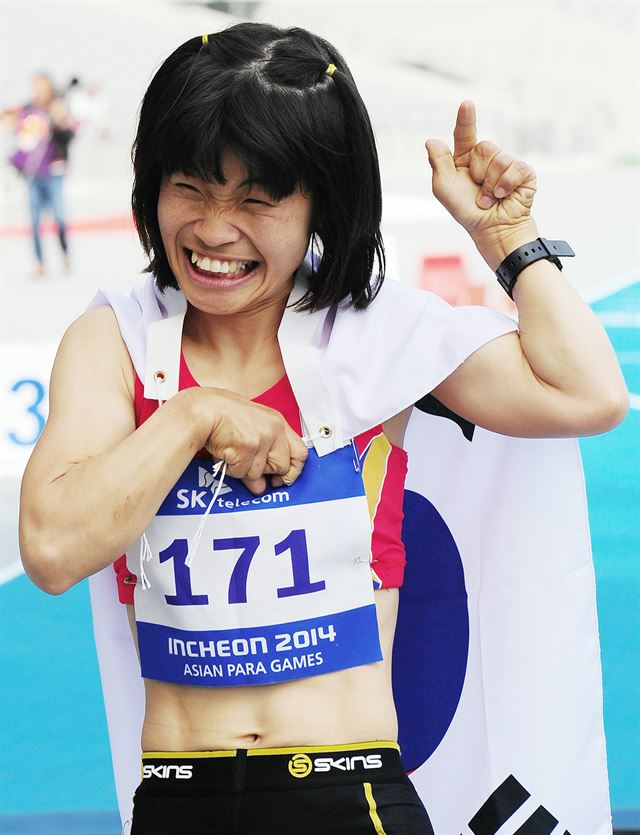 19일 오후 인천아시아드 주경기장에서 열린 2014 인천 장애인 아시안게임 육상 여자 200m T36 결승 경기에서 금메달을 획득한 한국의 전민재가 태극기를 몸에 두르고 활짝 웃고 있다. 연하뉴스