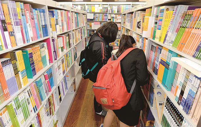 23일 서울 종로구 교보문고 광화문점을 찾은 두 여학생이 참고서를 고르고 있다. 교과서와 참고서 시장은 연 1조원대 시장을 형성하고 있다. 왕태석기자 kingwang@hk.co.kr