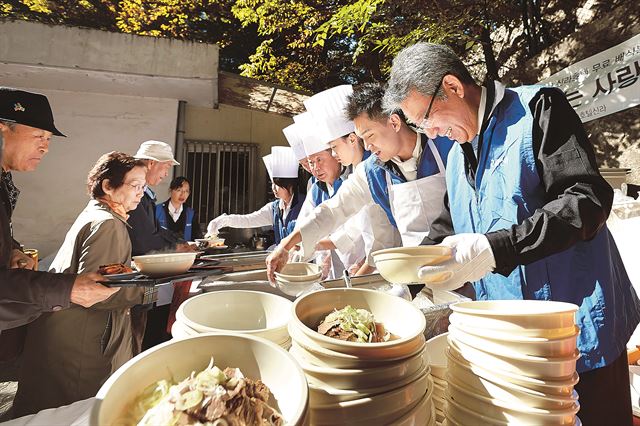 신라호텔 호텔사업부장 허병훈 전무(오른쪽 첫번째)와 총주방장 서상호 상무(오른쪽 네번째), 신라호텔 밥짓는 사랑방 봉사팀이 28일 서울 장충동에서 갈비탕을 저소득층과 노인에게 제공하고 있다. 신라호텔 제공