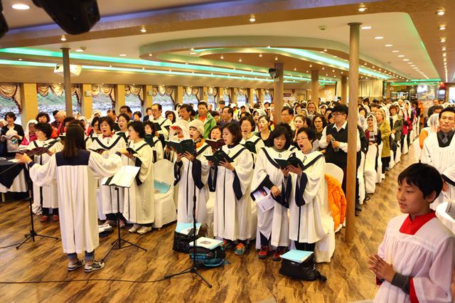 지난달 26일 진행된 경인아라뱃길 크루즈 미사 여행에 참가한 독산1동 성당 신도들이 선상미사를 진행하고 있다. 코레일관광개발 제공.