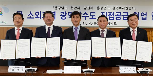 충남도는 4일 도청에서 천안ㆍ당진시, 홍성군, 한국수자원공사 와 ‘물 소외 지역 광역상수도 직접 공급 협업 협약’을 체결했다. 왼쪽부터 김홍장 당진시장, 최계운 한국수자원공사 사장, 안희정 충남지사. 구본영 천안시장, 김석환 홍성군수. 충남도 제공/2014-11-04(한국일보)