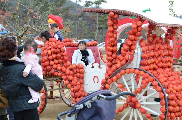 지난해 열린 청송사과축제장에서 어린이들이 바퀴까지 사과로 장식한 수례를 타고 있다. 청송군 제공