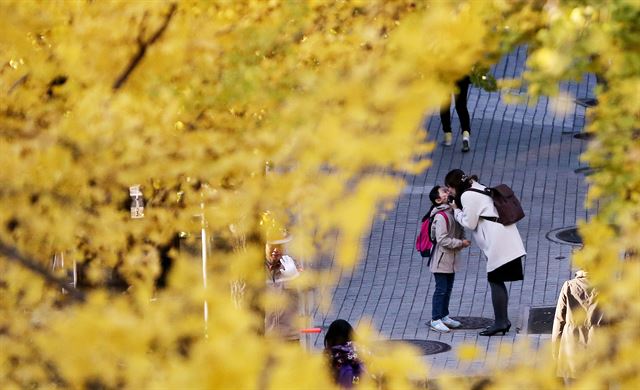 절기상 입동인 7일 오전 서울 서대문구의 한 초등학교 앞에서 두툼한 겉옷을 입은 한 어린이가 등굣길 인사를 나누고 있다. 연합뉴스