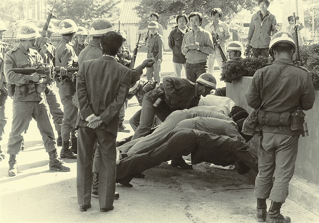 1980년 5월 광주 시내로 진입한 계엄군이 시민들을 체포해 길거리에 엎드리게 한 뒤 위협하고 있다. 한국일보 자료사진