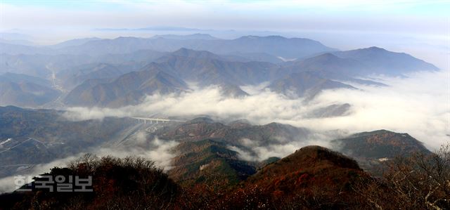 바위 절벽 끝인 안렴대에서 본 풍경. 발 아래로 까마득하게 대전통영고속도로가 지나고, 구름 위로 덕유산 자락 산들이 원근감을 드러낸다.