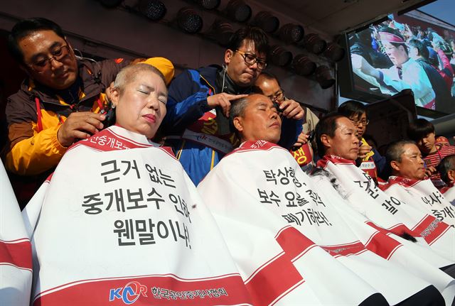 지난 7일 서울역 광장에서 열린 '부동산 중개보수 개악반대 총궐기대회'에서 한국공인중개사협회 회원들이 중개보수 인하 반대를 주장하며 삭발을 하고 있다. 국토교통부는 지난 3일 부동산 매매 거래 때 6억원 이상∼9억원 미만 구간과 전·월세 거래 때 3억원 이상∼6억원 미만 구간을 신설하고 보수 요율을 종전보다 낮추는 내용을 담은 부동산 중개보수 체계 개편안을 확정해 발표했다. 연합뉴스