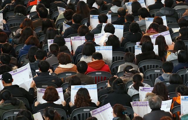 15일 오후 서울 성북구 고려대학교 화정체육관에서 열린 메가스터디 2015 대입 최종지원전략 설명회를 찾은 수험생과 학부모들이 정시지원 배치 참고표를 살펴보고 있다. 연합뉴스