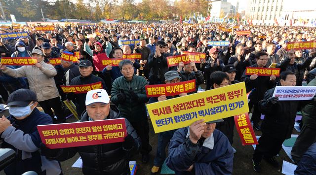 18일 오후 서울 중구 세종대로 서울광장에서 열린 '서울택시 생존권 사수 결의대회'에서 택시노동자들이 우버 서비스와 렌터카 택시영업 중단, 불합리한 택시악법 철폐 등을 촉구하며 구호를 외치고 있다. 뉴시스