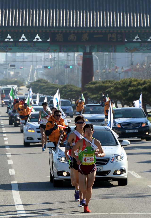 제60회 부산~서울 대역전경주대회 나흘째인 19일 김천-대전 대구간중 1소구간에 출전한 선수들이 김천시 초입 ‘영남제일문’을 통과해 직지사 방향으로 레이스를 펼치고 있다. 김천=왕태석기자 kingwang@hk.co.kr