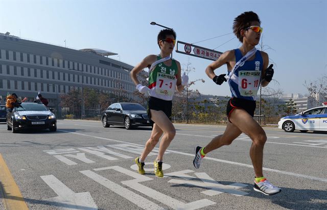 제60회 부산~서울 대역전경주대회 5일째인 20일 대전-천안 대구간 중 3소구간을 뛰는 선수들이 정부 세종청사를 지나가고 있다. 세종=왕태석기자 kingwang@hk.co.kr