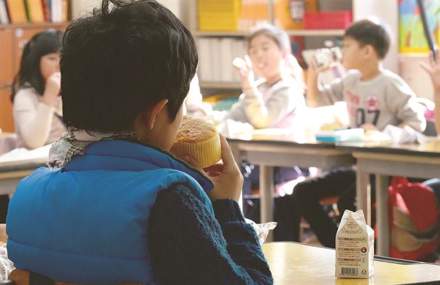 이날 학교비정규직 근로자의 파업으로 급식이 중단된 경기 수원의 한 초등학교에서 학생들이 점심시간에 빵과 우유를 먹고 있다. 뉴시스