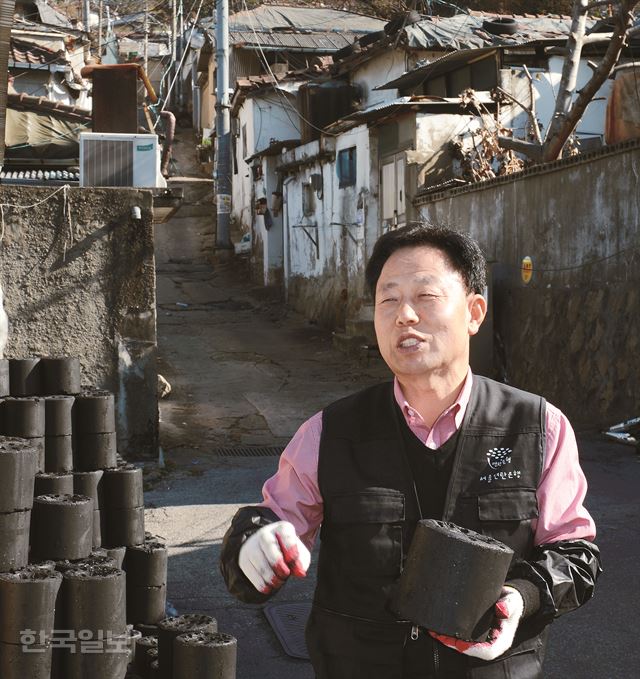 연탄은행 대표인 허기복 목사가 18일 서울의 달동네인 노원구 백사마을에서 연탄을 나르고 있다. 백사마을 초입에 있는 서울연탄은행 사무실은 강원도 원주에 있는 밥상공동체 연탄은행의 서울 사무소이자 연탄나눔운동의 전초기지다. 신상순 선임기자 ssshin@hk.co.kr