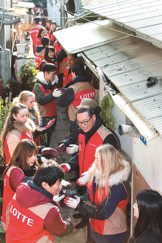 지난 20일 '온정나눔 연탄배달' 봉사활동에 참가한 이동우 롯데월드 어드벤처 대표(오른쪽 아래에서 두번째)와 임직원들이 서울 거여동 주민 가정에 연탄을 직접 배달하고 있다. 롯데월드 어드벤처 제공.