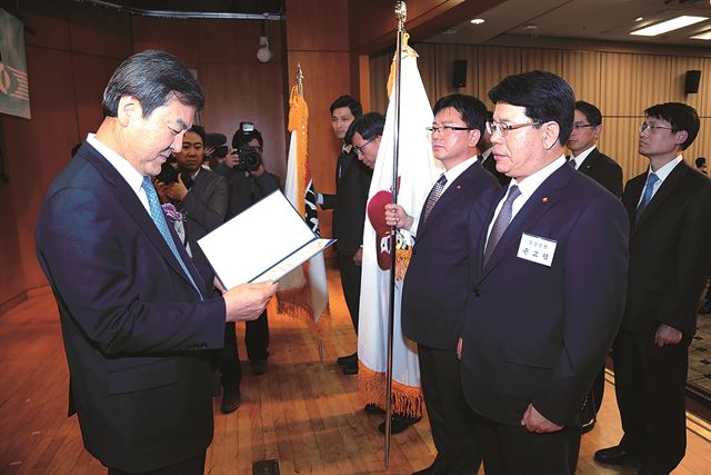 손교덕(오른쪽) 경남은행장이 '제8회 자금세탁방지의날' 행사에서 신제윤(왼쪽) 금융위원회 위원장으로부터 대통령표창을 받고 있다.