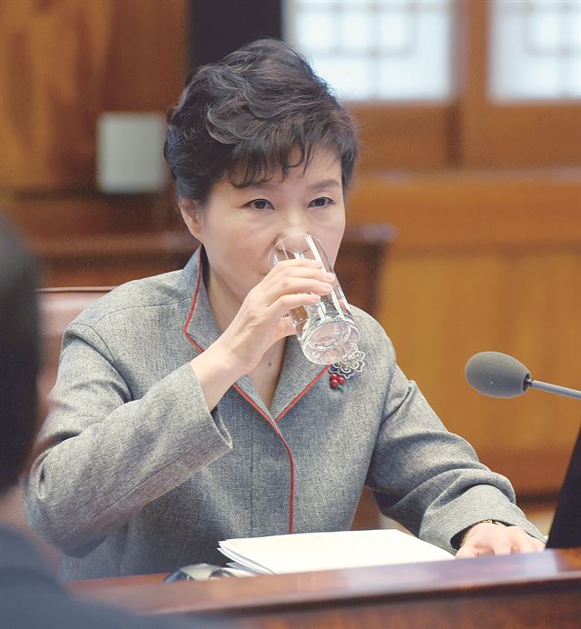 박근혜 대통령이 정윤회씨 국정 개입 및 측근 간 권력 암투 의혹을 일축했다. “근거 없는 일”, “말도 안 되는 얘기’ 같은 표현까지 동원됐다. 1일 청와대 수석비서관 회의에서다. 그러면서 청와대 문건이 유출된 것에 대해선 “국기 문란 행위”라고 강도 높게 질타했다. 이를 놓고 사실상 박 대통령이 검찰에 수사 가이드라인을 제시한 것 아니냔 지적이 나온다. 김진태 총장 취임 뒤 검찰이 청와대를 배신한 적이 없는 만큼 이번 수사 역시 비선 세력의 국정 농단 의혹이란 정곡을 파고들기보다 문건 유출 경위를 밝히는 데 초점이 맞춰질 거란 예상이 많다. 박 대통령이 회의 모두발언을 마친 뒤 물을 마시고 있다. 청와대 사진기자단