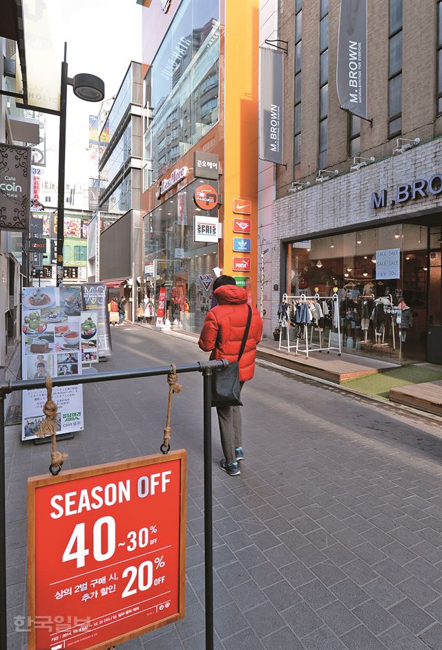 14일 서울 명동은 휴일임에도 연말의 흥청거리는 분위기는 거의 찾을 수 없고 대부분 매장에 할인행사를 알리는 안내문이 걸려 있다. 홍인기기자 hongik@hk.co.kr