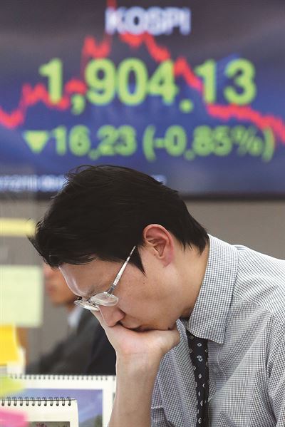 국제유가 급락 등의 여파로 코스피지수가 1,900선에 턱걸이하고, 원·달러 환율이 10원 넘게 떨어진 16일 서울 을지로 외환은행 본점 딜링룸 한 직원이 심각한 표정으로 업무를 보고 있다. 연합뉴스