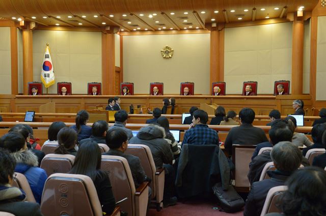 19일 서울 종로구 재동 헌법재판소 대심판정에서 열린 통합진보당에 대한 정당해산심판 청구 선고에서 재판관들과 방청객들의 박한철 헌재소장의 재판관 의견 설명을 듣고 있다. 연합뉴스