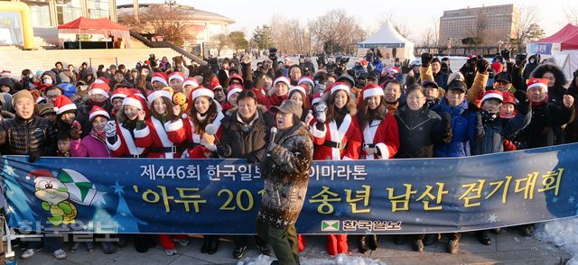 21일 서울 남산 국립극장 앞에서 열린 제446회 한국일보 거북이 마라톤 송년 남산 걷기대회에서 이준희(가운데) 한국일보 사장과 산타 복장을 한 2014 미스코리아 등 참가자들이 출발에 앞서 힘차게 구호를 외치고 있다. 신상순 선임기자 ssshin@hk.co.kr