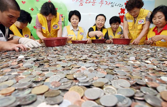 대한적십자 인천지사 자원봉사자들이 인천공항 이용객들이 기부한 동전을 분류하고 있다. 인천지역 다문화가정과 소년소녀가장을 위해 사용된다. 한국일보 자료사진