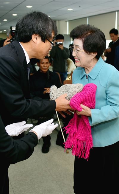 이희호 여사가 23일 광주 시각장애인협의회 송년 행사에서 회원들이 북한에 보내기 위해 만든 방한 용품을 건네받고 있다. 광주=연합뉴스