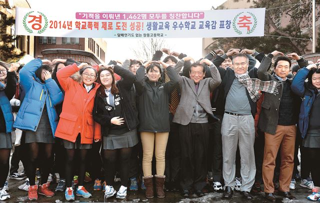 올해 '학교폭력 제로'에 성공한 서울 창동고 학생과 교직원들이 24일 교내에서 축하식을 연 뒤 교문 앞에서 머리 위로 하트를 그리며 기념촬영을 하고 있다. 왕태석 기자 kingwang@hk.co.kr