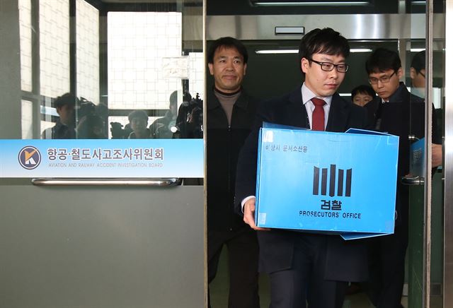 검찰이 '땅콩 회항'과 관련해 대한항공과 유착 의혹을 받는 국토교통부 김모 조사관의 사무실과 자택을 압수수색한 지난 24일 검찰관계자들이 김포공항 인근의 국토부 항공철도사고조사위원회에서 압수품을 들고 나오고 있다. 연합뉴스