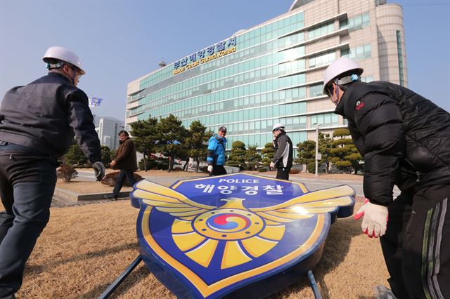 지난달 30일 부산시 영도구 부산해양경비안전서에서 작업자들이 건물에서 '해양경찰' 간판을 내리고 있다. 연합뉴스