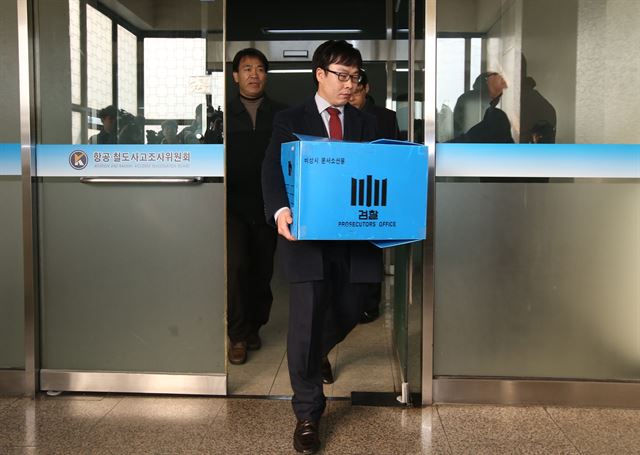 지난해 12월 검찰관계자들이 '땅콩 회항'과 관련해 김포공항 인근의 국토부 항공철도사고조사위원회에서 압수품을 들고 나오고 있다. 연합뉴스