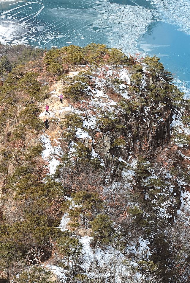 깎아지른 암벽을 따라 오르면 얼어 붙은 충주호의 물길이 나타난다.