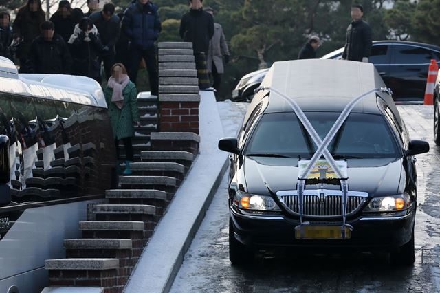 지난 달 13일 '정윤회 국정개입 문건' 유출 혐의로 수사를 받다가 스스로 목숨을 끊은 최모 경위의 발인식이 열린 서울 강동구 고덕동 명일동성당에서 고인의 시신과 영정을 실은 운구차가 성당을 떠나는 모습. 연합뉴스