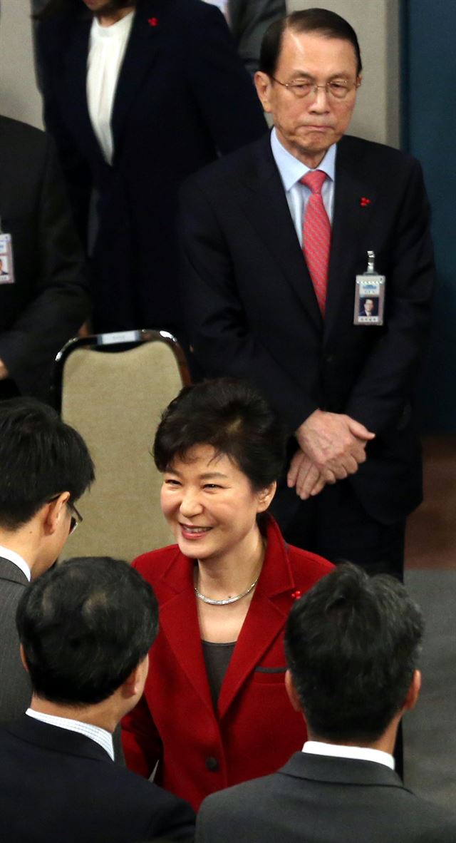 박근혜 대통령이 12일 청와대 춘추관에서 신년 기자회견을 마친 후 기자들과 일일이 인사를 나누는 동안 김기춘(뒤) 비서실장이 박 대통령을 수행하고 있다. 홍인기기자 hongik@hk.co.kr