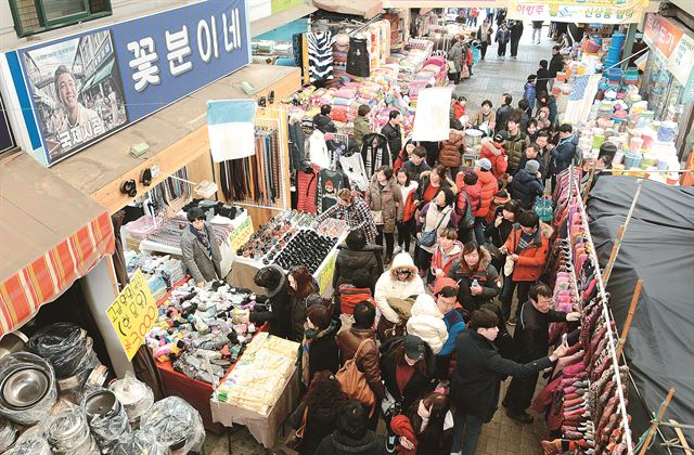 영화 ‘국제시장’의 흥행으로 부산 중구 국제시장에 사람들이 몰리고 있다. 관광객들이 영화 속 주인공의 가게인 꽃분이네 앞에 몰려들어 기념 사진을 찍거나 상점의 물건을 구경하고 있다. 부산=전혜원기자 iamjhw@hk.co.kr