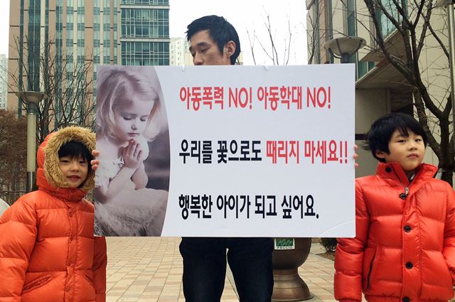 16일 오전 인천시 연수구의 한 아파트 단지 앞에서 '송도국제도시 주민연합회'의 한 회원이 두 아들과 함께 인천 어린이집 폭행 사건 재발 방지대책 마련을 촉구하는 1인 시위를 하고 있다. 연합뉴스