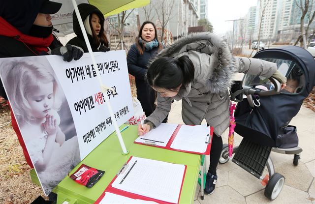 16일 오전 인천시 연수구의 한 아파트 단지 앞에서 송도국제도시 주민연합회 회원들이 인천 어린이집 폭행 사건 재발방지 대책 마련을 촉구하는 서명을 받고 있다. 연합뉴스