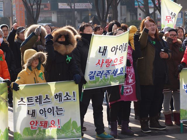 어린이집 아동 학대에 분노한 부모들이 19일 오전 인천시청 앞 미래광장에서 가슴에 녹색 리본을 단 채 아동학대 근절을 요구하는 집회를 열고 있다. 인천=뉴시스