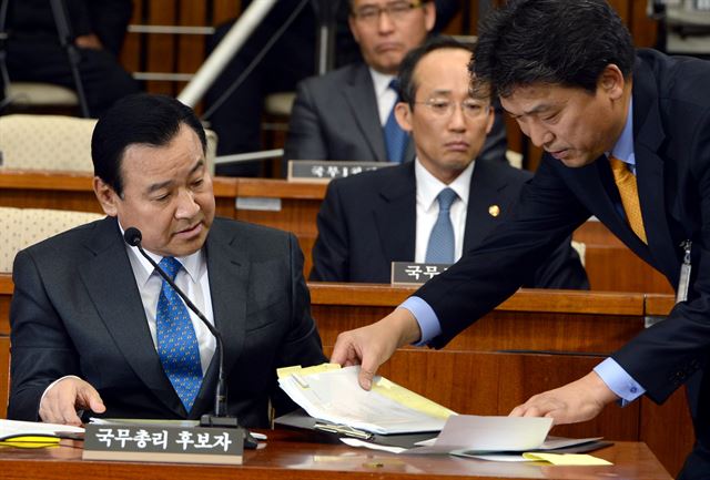 이완구 총리 후보자가 11일 국회에서 열린 인사청문회에서 답변자료를 받아보고 있다. 왕태석기자 kingwang@hk.co.kr