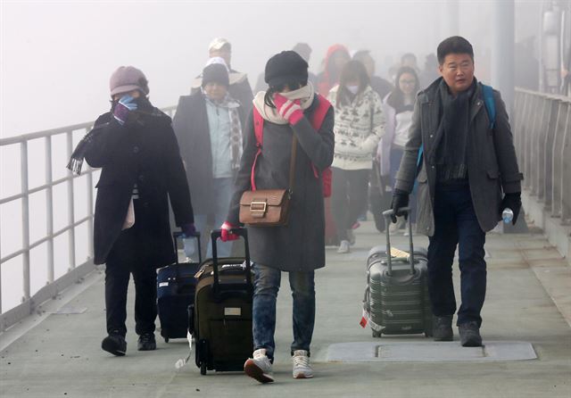 사고를 당한 공항 리무진 버스에 타고 있던 관광객들이 걸어서 다리를 건너고 있다. 연합뉴스