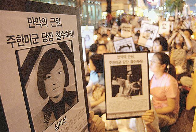 미군 장갑차 사고로 숨진 여중생 효순·미선양 3주기 반미 촛불 추모행사가 열린 2005년 6월 참석자들이 서울 광화문 교보빌딩 앞에서 희생자 영정을 들고 있다. 한국일보 자료사진.