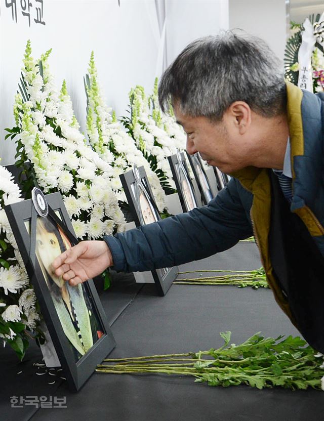 지난 13일 오후 부산 금정구 부산외대 남산동 캠퍼스 체육관 1층에 마련된 추모관에서 故 김진솔(당시 20·여·태국어과)씨의 아버지 김판수(56)씨가 딸의 사진을 쓰다듬고 있다.