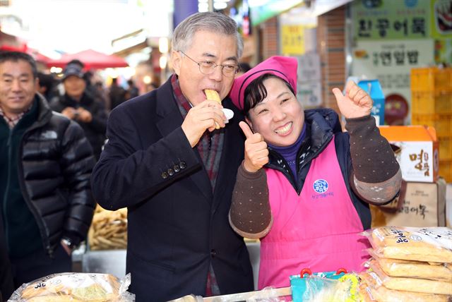 새정치민주연합 문재인 대표가 설연휴 첫날인 18일 부산시 중구 부평깡통시장을 찾아 상인들과 인사하면서 부산어묵을 맛보고 있다. 연합뉴스