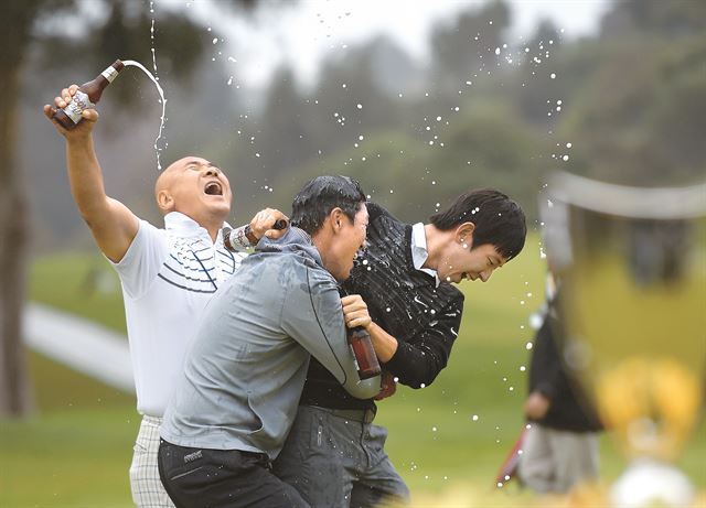 제임스 한이 23일 미국프로골프(LPGA) 투어 노던트러스트 오픈 4라운드 18번 그린에서 우승을 확정 지은 순간 제이슨 오(왼쪽)와 노승열의 맥주 세례를 받고 있다. 퍼시픽 팰리세이즈=APㆍAFP 연합뉴스