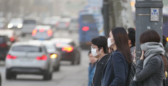 설 연휴가 끝난 뒤 맞는 첫 평일인 23일 중국발 황사가 한반도를 뒤덮은 가운데 서울 종로구 세종로네거리에서 마스크를 쓴 시민들이 출근길을 서두르고 있다. 연합뉴스