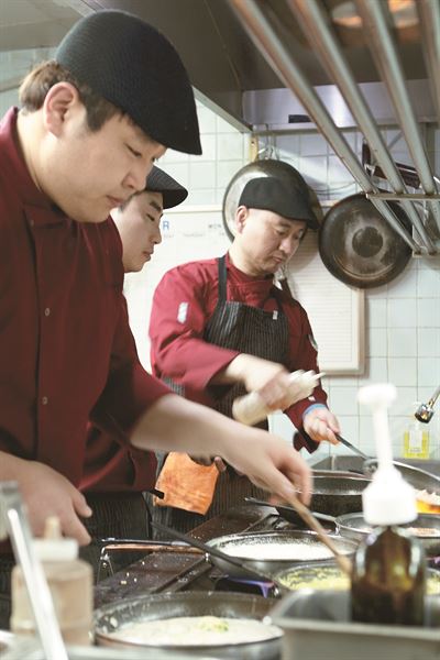 인간의 원초적 본능을 자극하는 식탐을 소재로 한 ‘쿡방’이 인기다. 정신건강의학과 전문의들은 “쿡방을 통해 음식에 대한 간접경험만 축적하면 뇌에 내성이 생겨 자극적인 음식을 찾을 수 있다”고 지적하고 있다. 사진은 광화문 퓨어아레나 레스토랑 주방 모습. 한국일보 자료사진