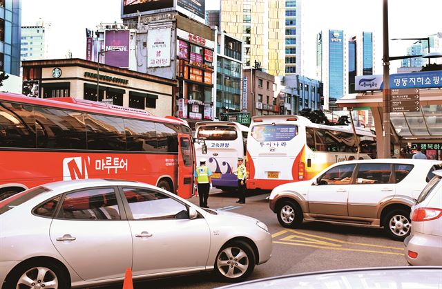 서울 명동 롯데백화점 앞 편도 4차선 도로가 관광버스와 승용차들로 극심한 정체를 빚고 있다. 한국일보 자료사진